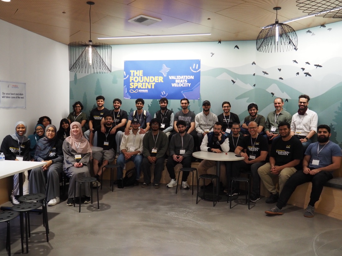 Builders and mentors posed under the “Validation Beats Velocity” Founder Sprint banner.