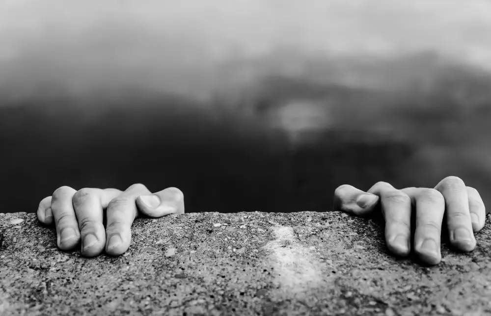Concerned entrepreneur standing at the edge of a cliff, symbolizing uncertainty and risk in business decisions.
