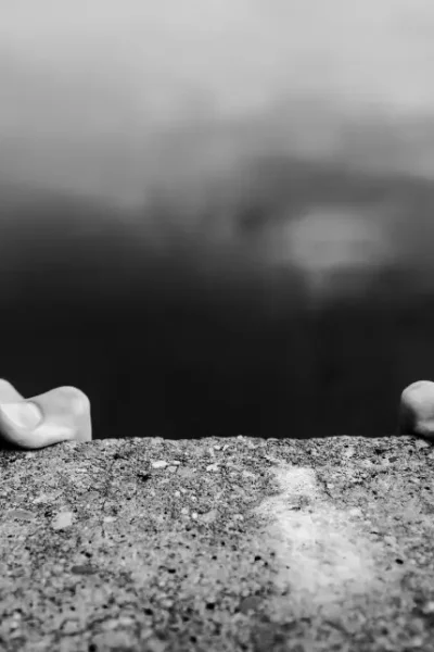 Concerned entrepreneur standing at the edge of a cliff, symbolizing uncertainty and risk in business decisions.